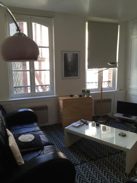 a living room with a couch and a coffee table at Rue Des Lingots Apartment in Honfleur