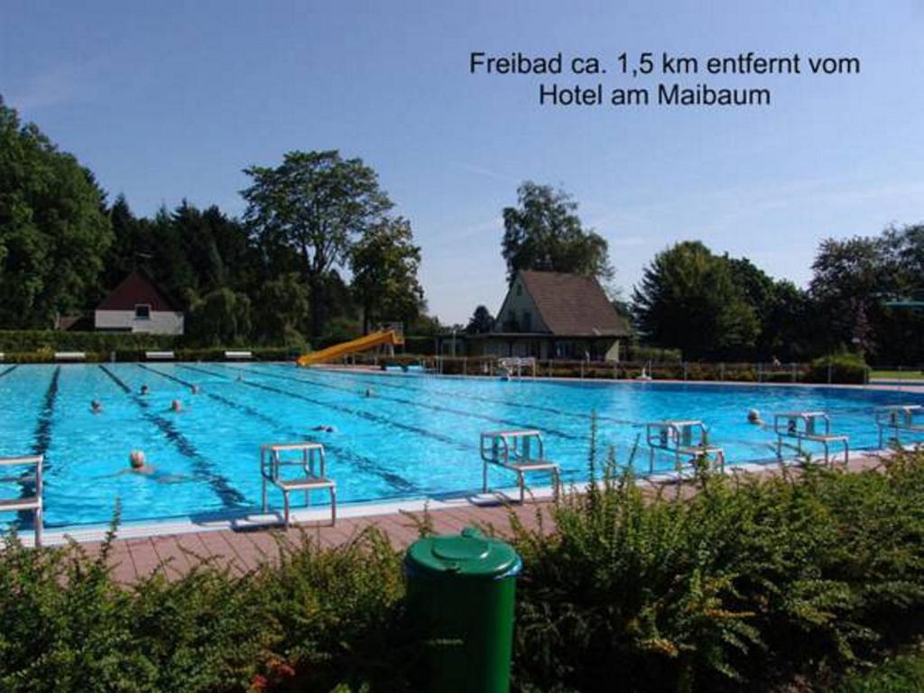 una gran piscina con sillas. en Hotel am Maibaum, en Neuenrade