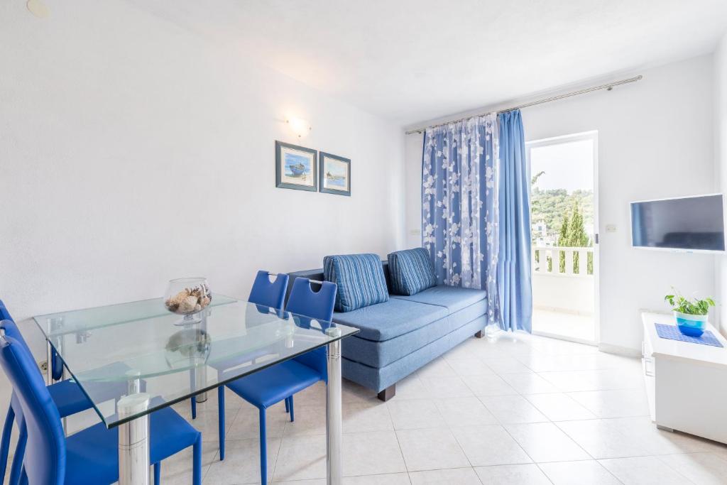a living room with a blue couch and a glass table at Apartments Nikolina in Hvar