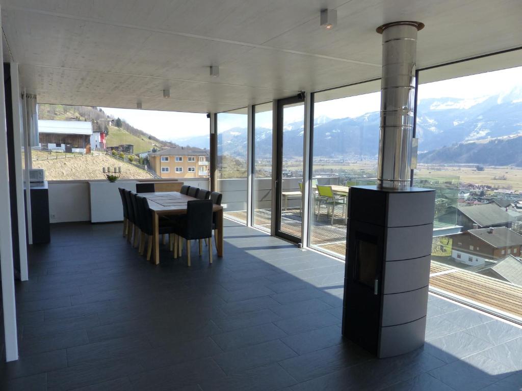 a dining room with a table and views of mountains at Glas House - Design Holiday Home in Piesendorf