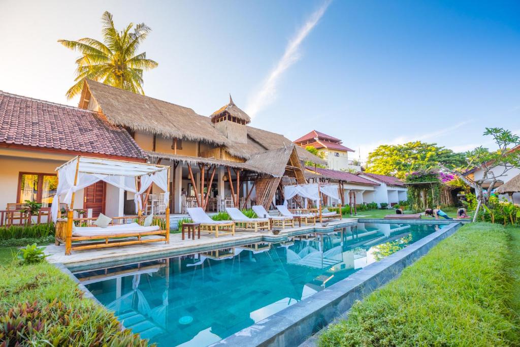 una imagen de una piscina en un complejo en Nativo Lombok Hotel en Kuta Lombok