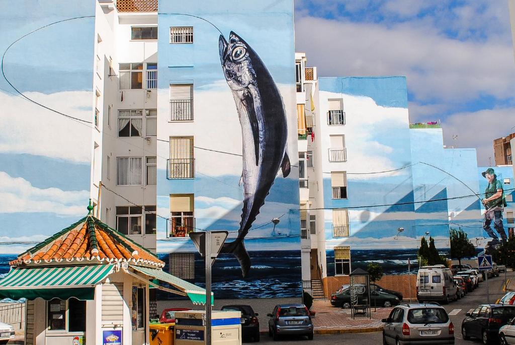 a building with a large painting of a fish on it at Apartamentos Miguel Angel in Estepona