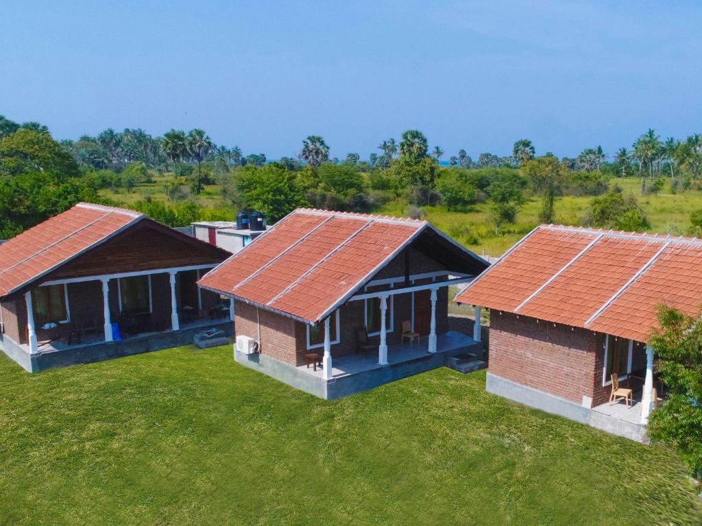 an overhead view of three houses with red roofs at Pasikudah Eco Village Hotel in Pasikuda
