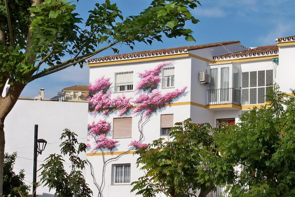 a white building with pink flowers on it at Apartamentos Miguel Angel in Estepona