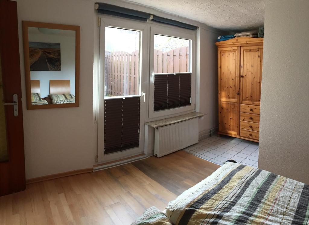 een slaapkamer met een bed en 2 grote ramen bij Austernfischer Fewo I in Borkum