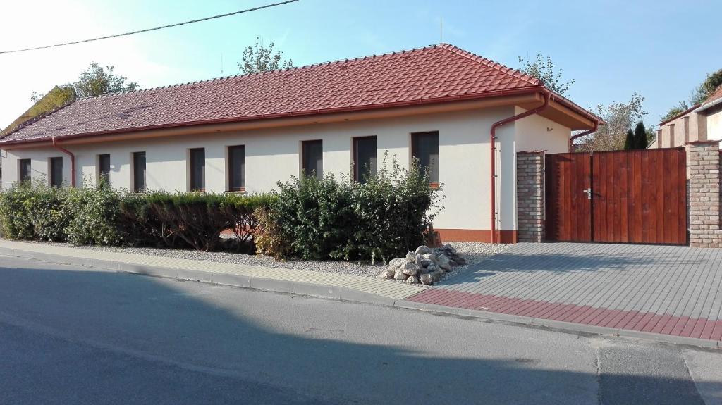 ein weißes Haus mit rotem Dach auf einer Straße in der Unterkunft Apartmány U Jakuba in Lednice