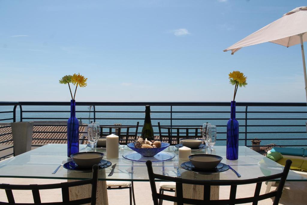 una mesa con sillas y jarrones azules en el balcón en Apartamento Calypso, en Peñíscola