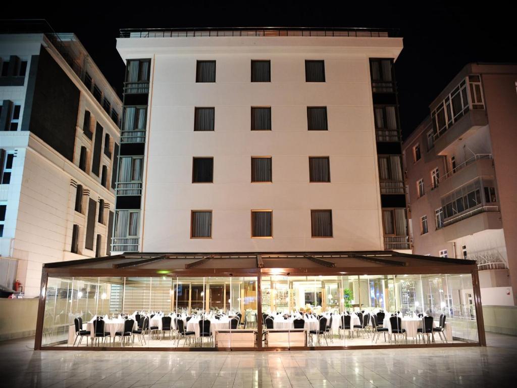 een gebouw met tafels en stoelen ervoor bij Niza Park Hotel in Ankara