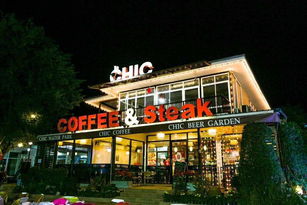 a building with a coffee and skeeshak sign at night at The Chic 101 Hotel in Selaphum