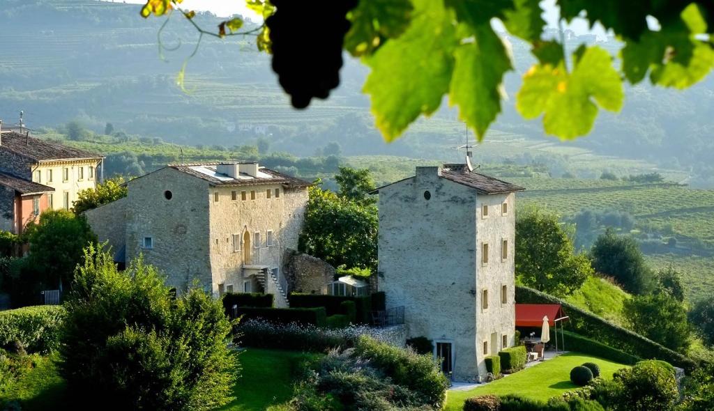 un ensemble de châteaux sur une colline verdoyante plantée d'arbres dans l'établissement Pianaura Suites, à Marano di Valpolicella