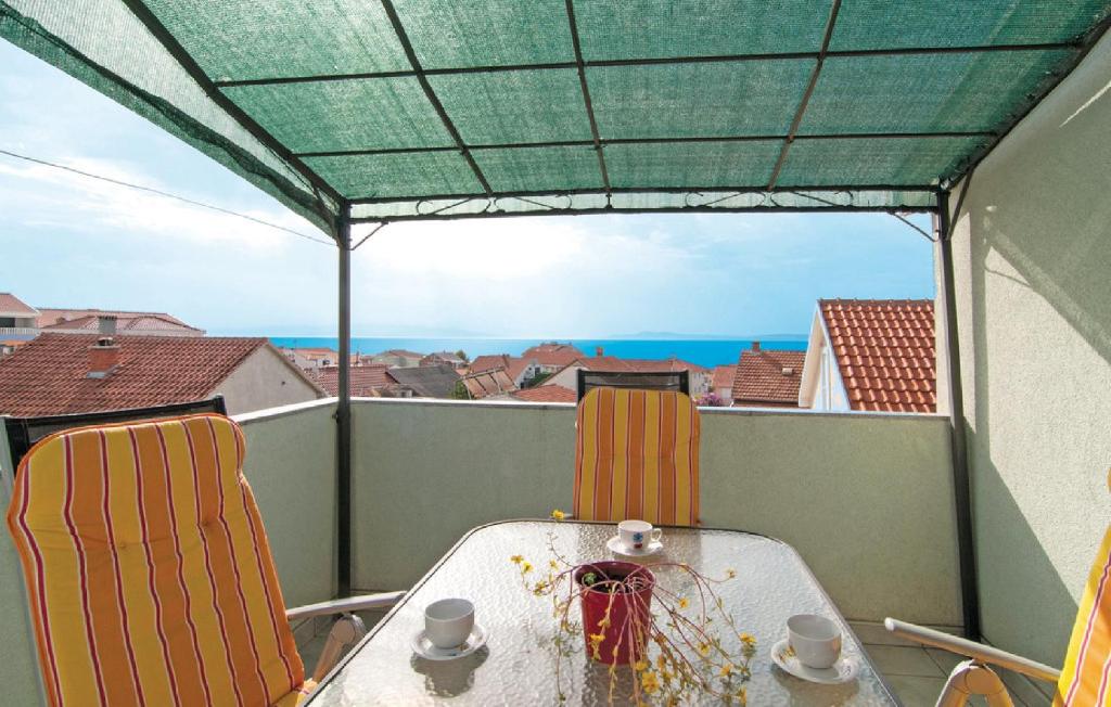 una mesa y sillas en un balcón con vistas al océano en Apartments Otok, en Trogir