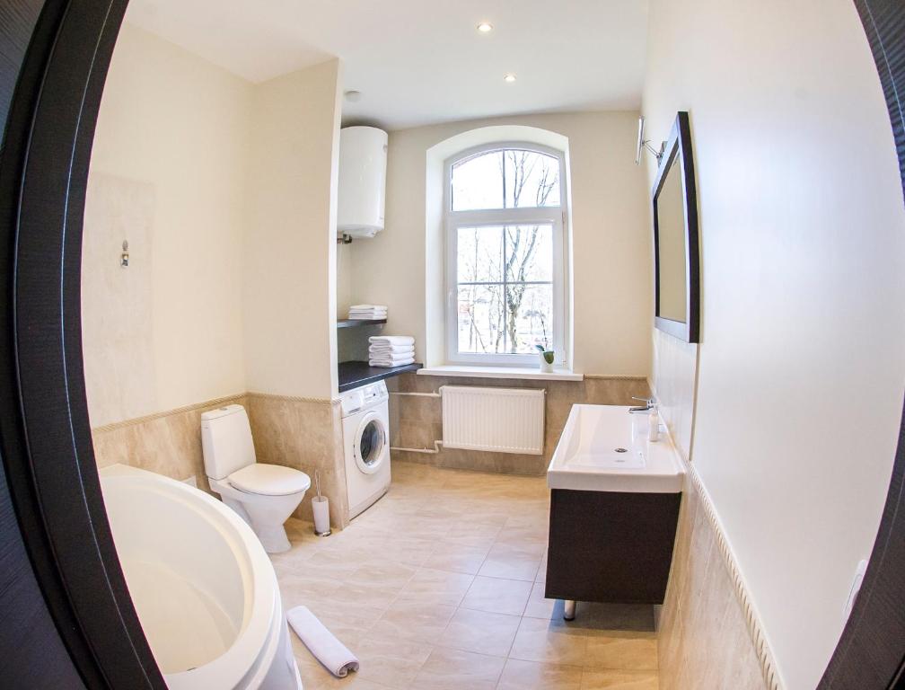 łazienka z umywalką, toaletą i oknem w obiekcie Red Brick Apartments w Kłajpedzie