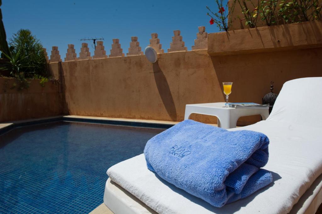 a bed sitting next to a swimming pool at Riad Yacout in Meknès