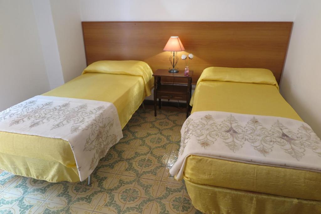 una camera con due letti e un tavolo con una lampada di Appartamento Petrarca a Gallipoli