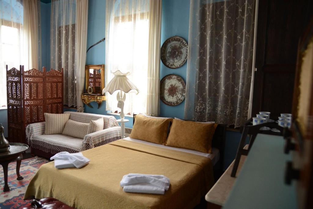 a blue room with a bed and a couch at Cunda Zehra Teyzenin Evi in Ayvalık