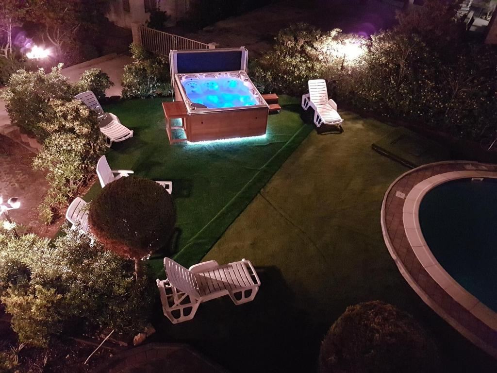 an overhead view of a swimming pool with lawn chairs and a pool table at Apartments Stengl in Rab