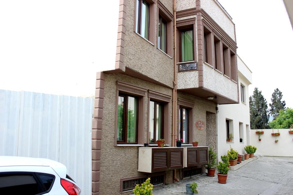 un edificio con finestre e un'auto parcheggiata di fronte di Selena Hotel a Selçuk