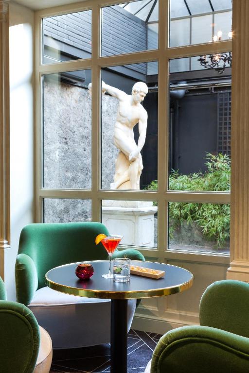 a room with a statue and a table and chairs at Hotel Barsey by Warwick in Brussels