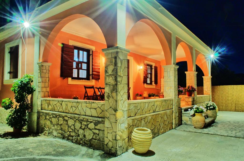 a house with an orange wall and some vases at Casa Elaia in Áyios Dhimítrios