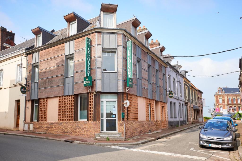 un bâtiment dans une rue avec une voiture garée devant dans l'établissement chambres d'hotes du colvert, à Forges-les-Eaux