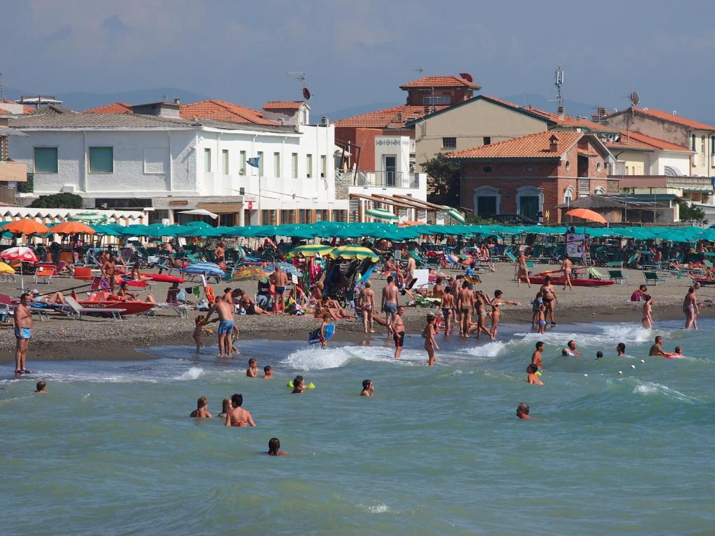 a group of people in the water at a beach at Hotel Aurora in Marina di Cecina