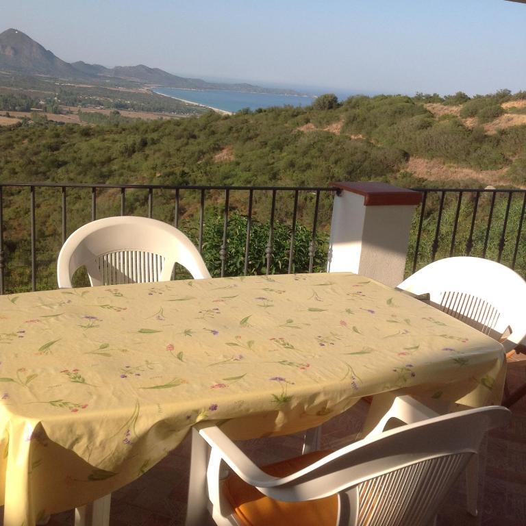 a table and chairs on a balcony with a view at Casa Solaria Villetta singola panoramicissima in Costa Rei