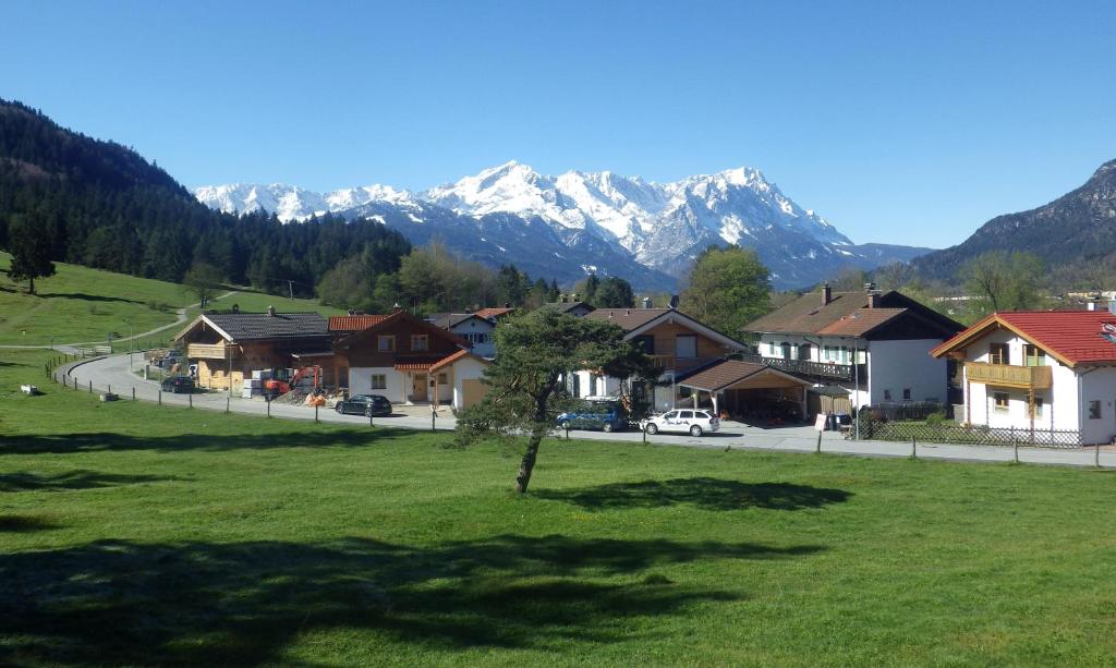 ein Dorf mit Häusern und Bergen im Hintergrund in der Unterkunft Farchant-Zugspitze in Farchant