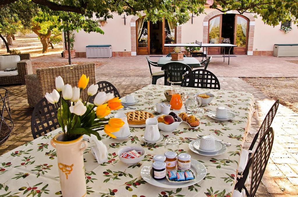 een tafel met eten en een vaas met bloemen erop bij Pathirion b&b in Rossano