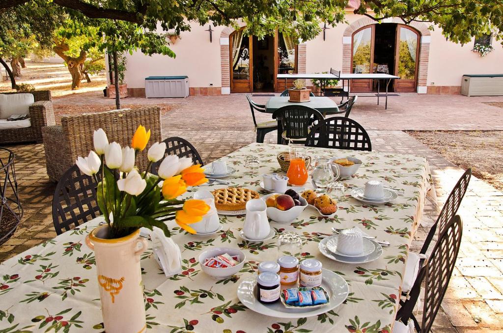 a table with food and a vase of flowers on it at Pathirion b&b in Rossano