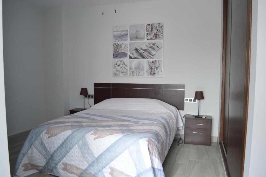 a bedroom with a bed and a nightstand with two lamps at Apartamento Prado - Casa Eva in Ardales
