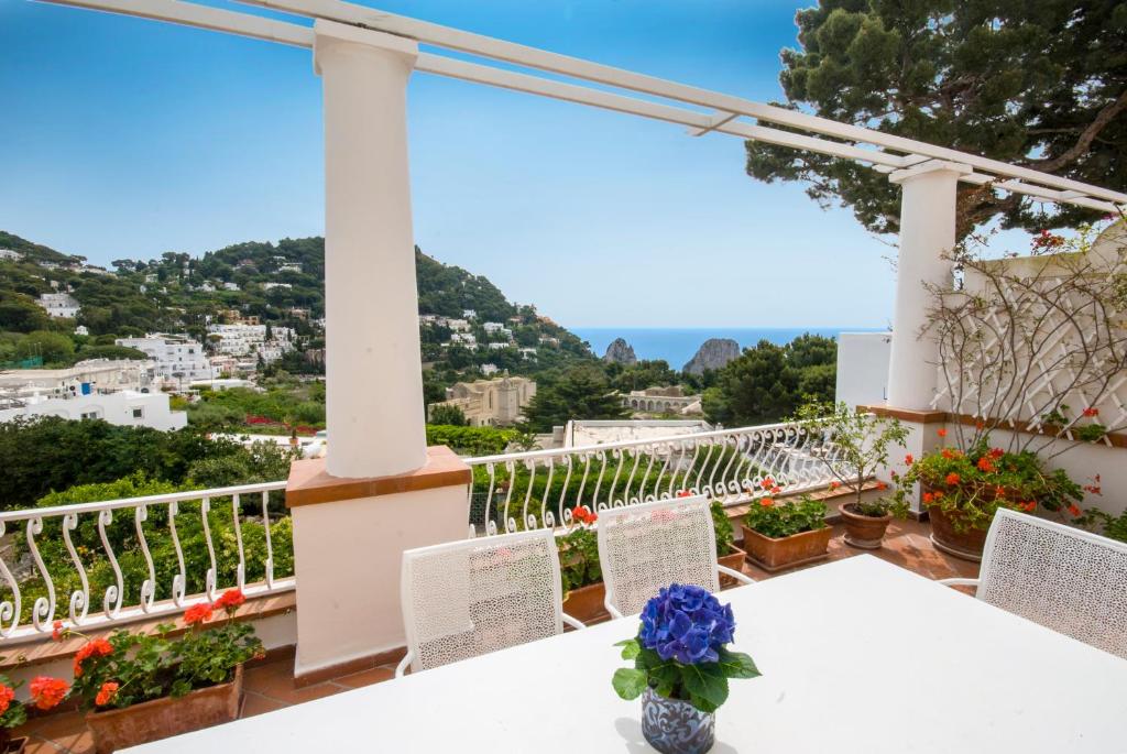 uma mesa e cadeiras numa varanda com vista em Carthusia Suites em Capri