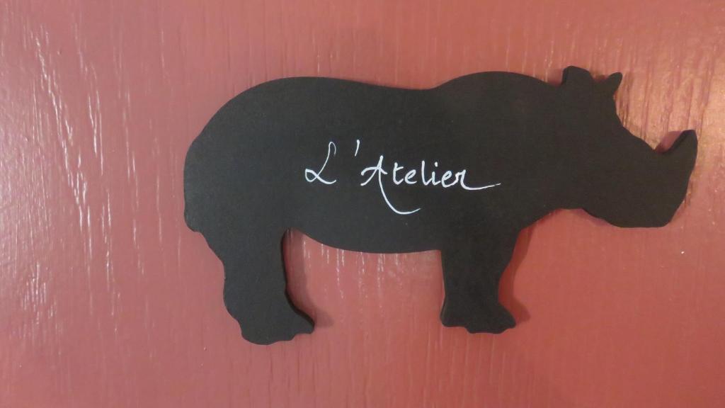 une silhouette noire d’un ours sur un mur rouge dans l'établissement A la belle histoire, à Châteauneuf-sur-Isère