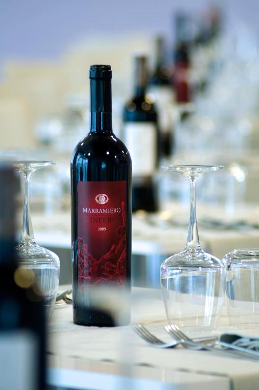a bottle of wine sitting on a table with two glasses at Aurea Hotel in Tortoreto Lido