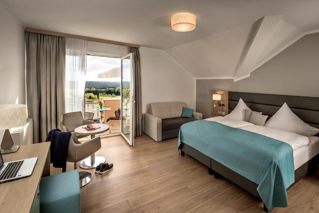 Habitación de hotel con cama, escritorio y habitación en Hotel-Restaurant Distlerhof, en Leinburg