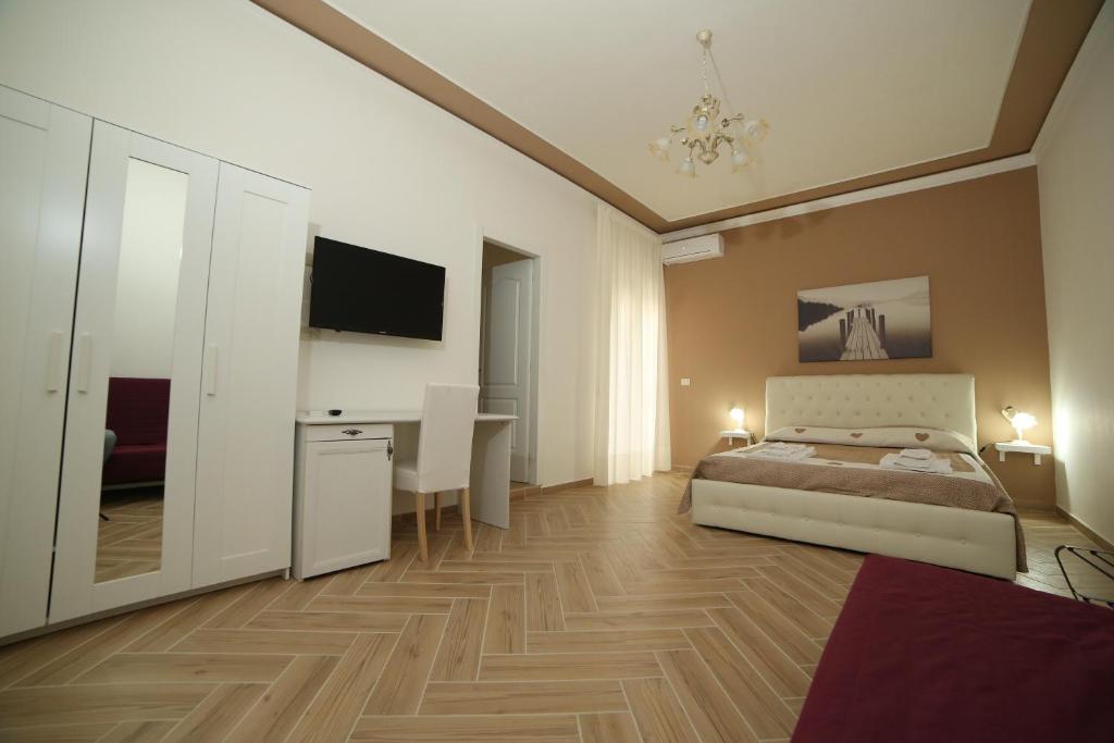 a bedroom with a bed and a desk and a television at Antichi Soffitti in Catania
