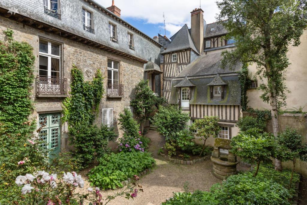 une cour d'une ancienne maison ornée de plantes et de fleurs dans l'établissement Breizh Cocon by Cocoonr, à Rennes