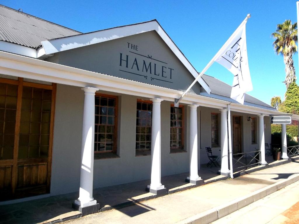 a building with two flags in front of it at The Hamlet Country Lodge in Ceres