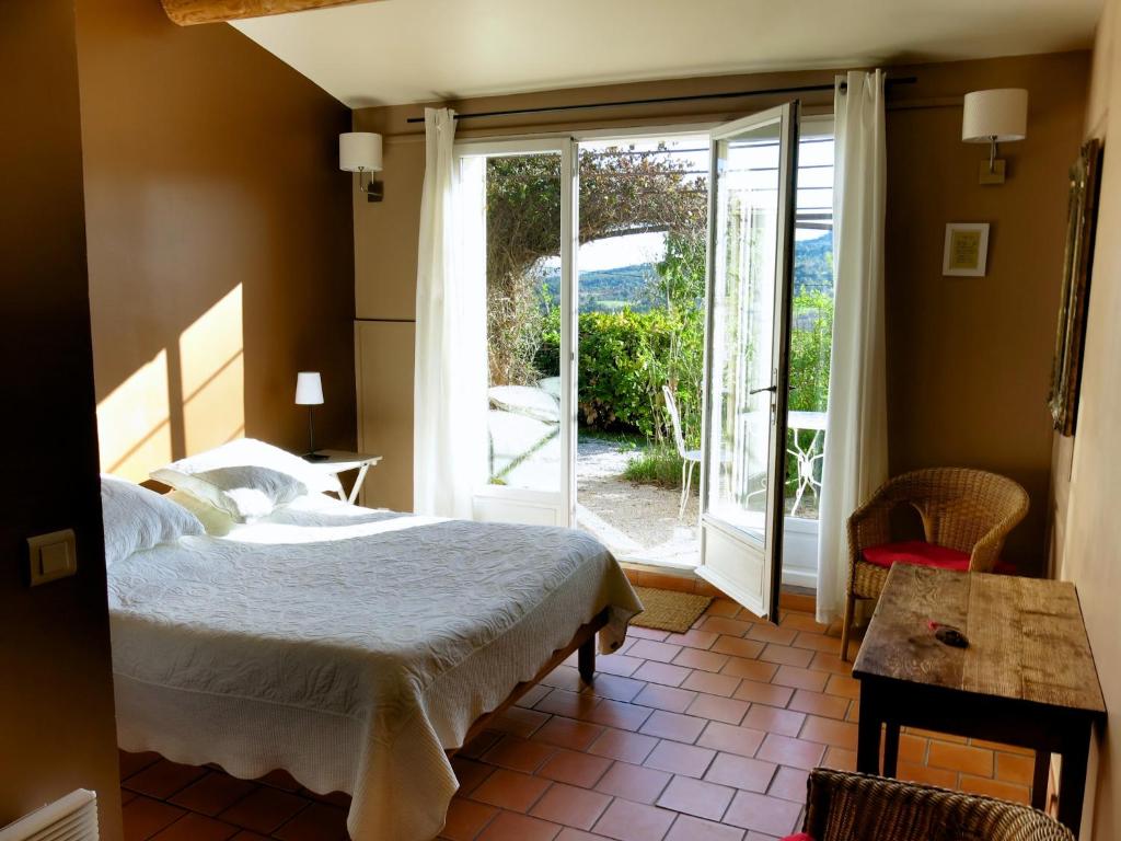 ムスティエ・サント・マリーにあるLes Oliviersのベッドルーム1室(ベッド1台付)、スライド式ガラスドアが備わります。