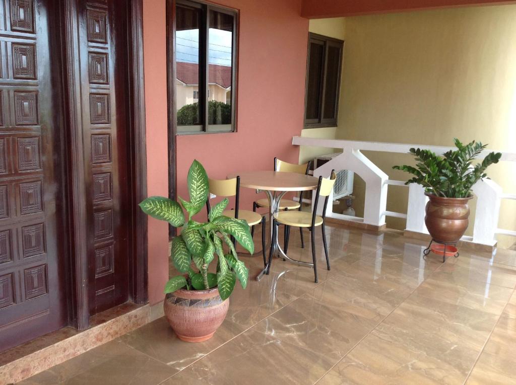 een kamer met planten en een tafel en stoelen bij Benconi Lodge in Accra