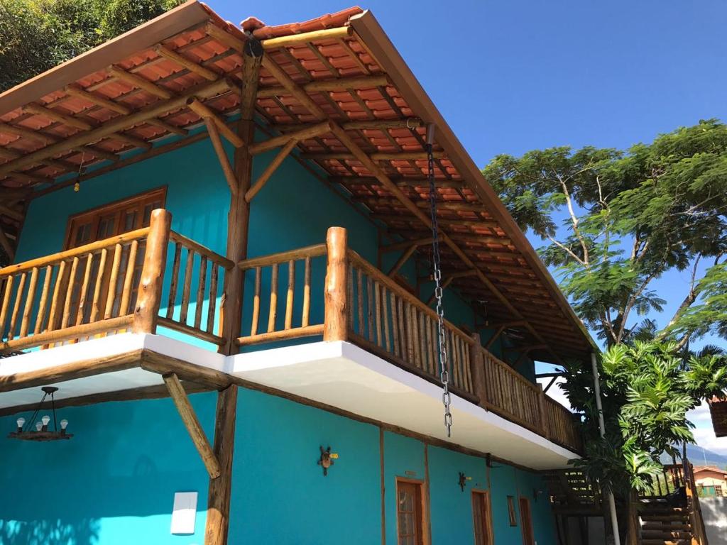 a house with a balcony on top of it at Espaço Dona Florinha in Ilhabela