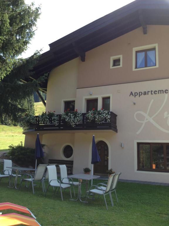 a building with chairs and tables and a balcony at Appartements Kröll in Saalbach-Hinterglemm