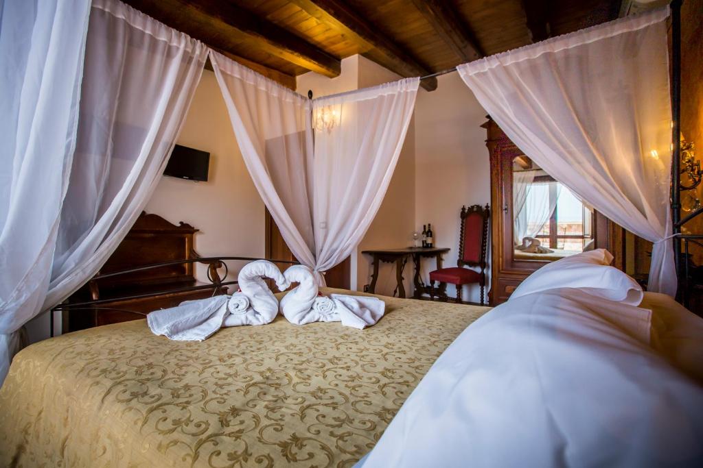 Łóżko lub łóżka w pokoju w obiekcie Palazzo Giunta - Porta Marina Ortigia