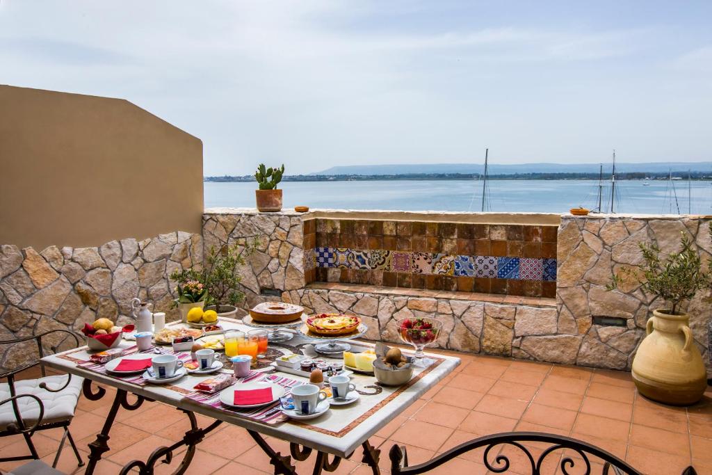 stół z jedzeniem na patio w obiekcie Palazzo Giunta - Porta Marina Ortigia w Syrakuzach