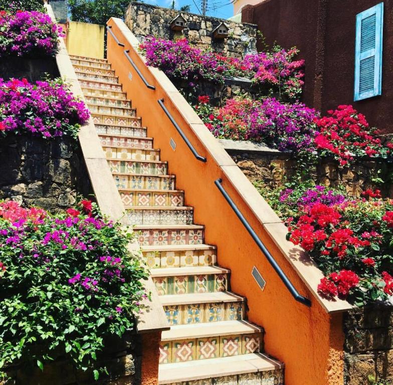 an orange stairway with flowers on the side of a building at Pousada Manjericão in Guaramiranga