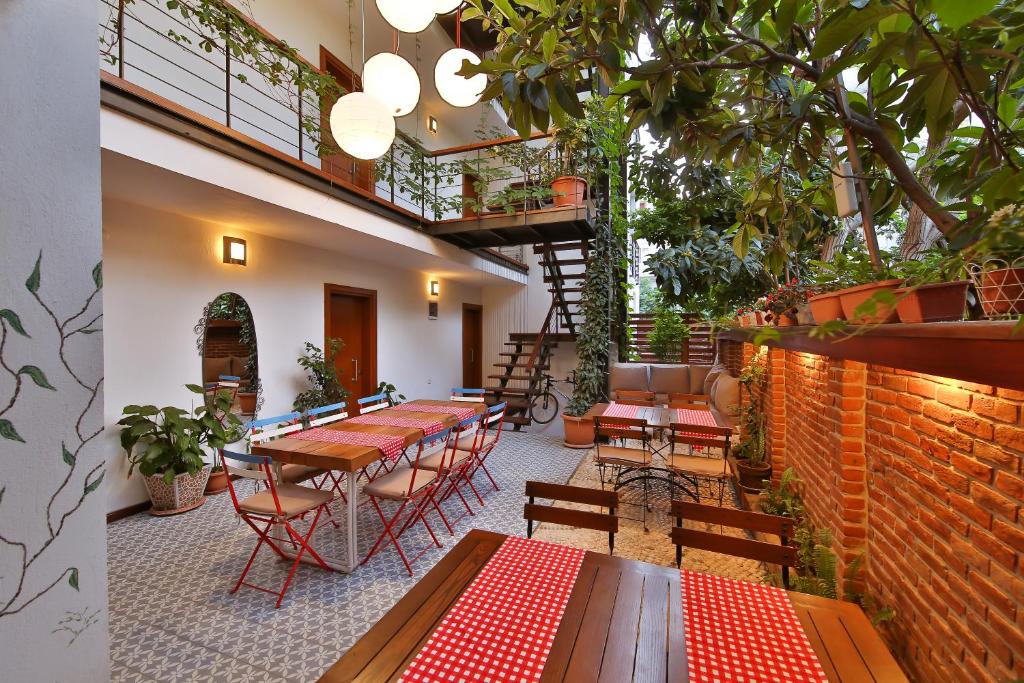 een patio met tafels en stoelen en een bakstenen muur bij Mare Nostrum Apart in Kas
