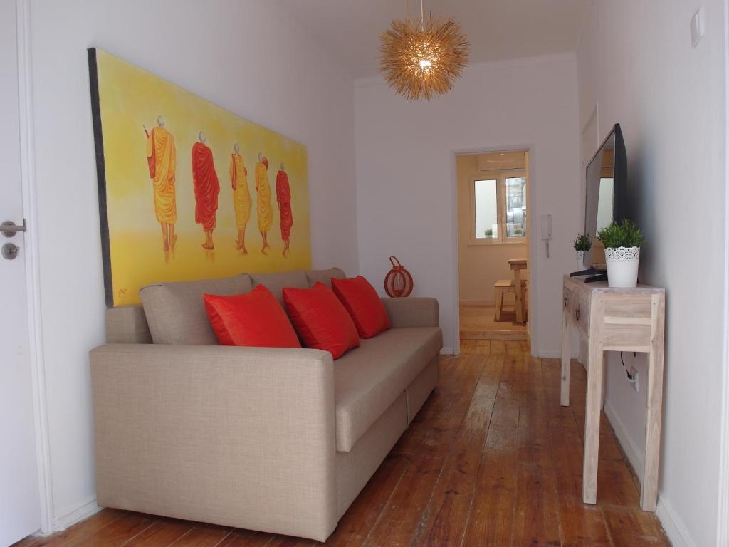 ein Wohnzimmer mit einem Sofa und roten Kissen in der Unterkunft BairroSweethome in Lissabon