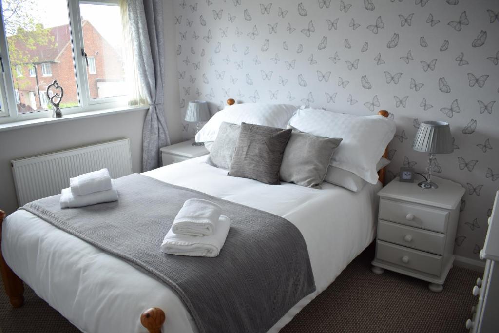 a bedroom with a large white bed and a window at 103 Bewick Serviced Accommodation in Newton Aycliffe