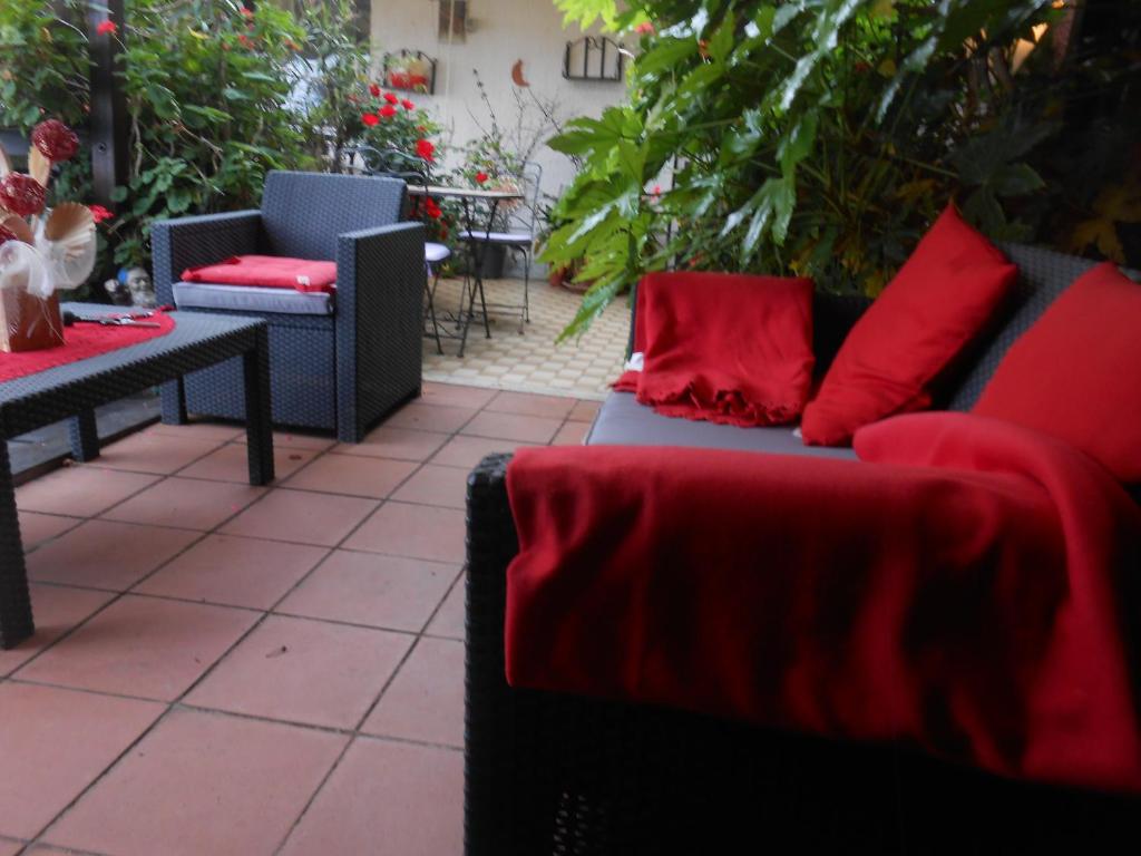 eine Terrasse mit zwei Sofas und roten Kissen in der Unterkunft Garden Villa Sea View in Riomaggiore