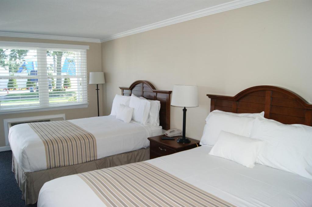 a hotel room with two beds and a window at Cape Cod Family Resort and Parks in West Yarmouth