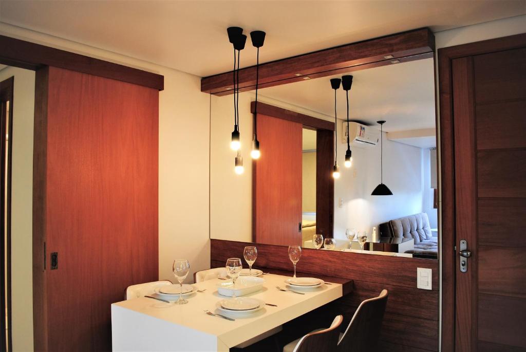 ein Esszimmer mit einem Tisch und einem Spiegel in der Unterkunft Apartamento Moderno Centro Gramado in Gramado